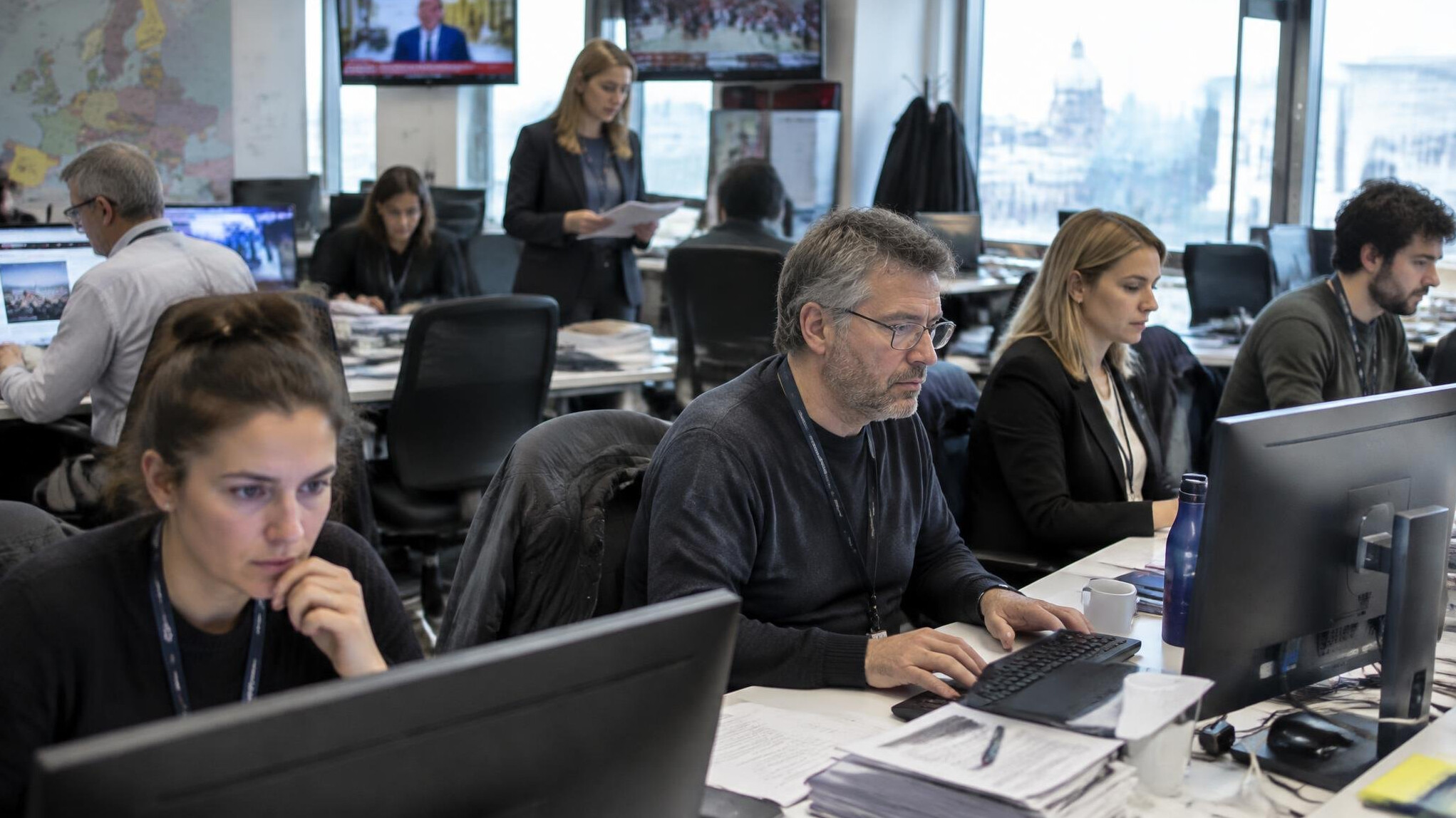 Journalists working together in a busy newsroom